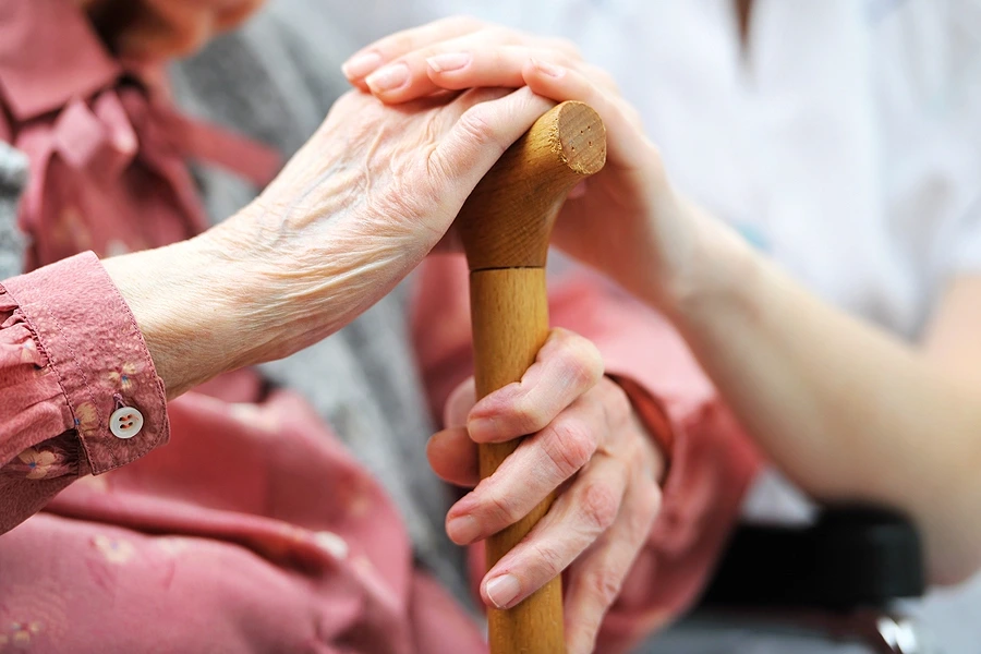 Senior woman holding care giver_s hands